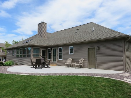 Ranch house with back patio sitting area and tan siding