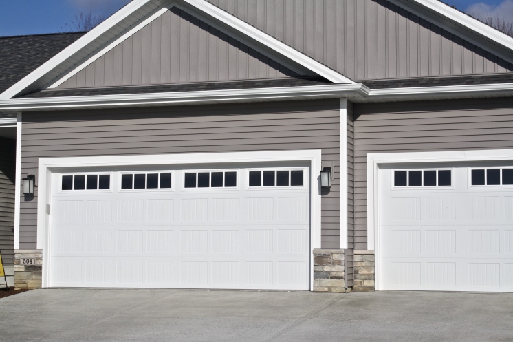 Grey house with white carriage style garage doors
